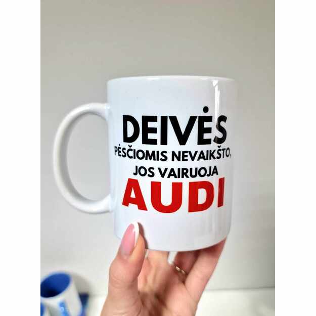 SU DEFEKTU. Puodelis DEIVĖS PĖSČIOMIS NEVAIKŠTO, JOS VAIRUOJA AUDI 